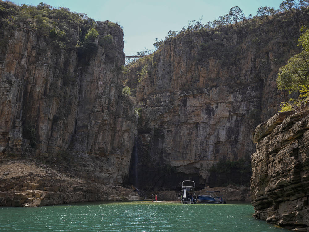A tourist boat navigates through a canyon in Furnas Lake, near Capitolio City, Brazil, on Sept. 2, 2021. A massive slab of rock broke away on Saturday from the canyon wall and and toppled onto pleasure boaters killing at least six people and injuring dozens at the popular tourist destination in Minas Gerais state.