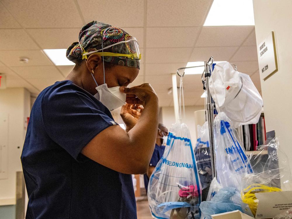 A medical worker puts on a mask before entering a negative pressure room with a COVID-19 patient in the ICU ward at UMass Memorial Medical Center in Worcester, Mass., last week.