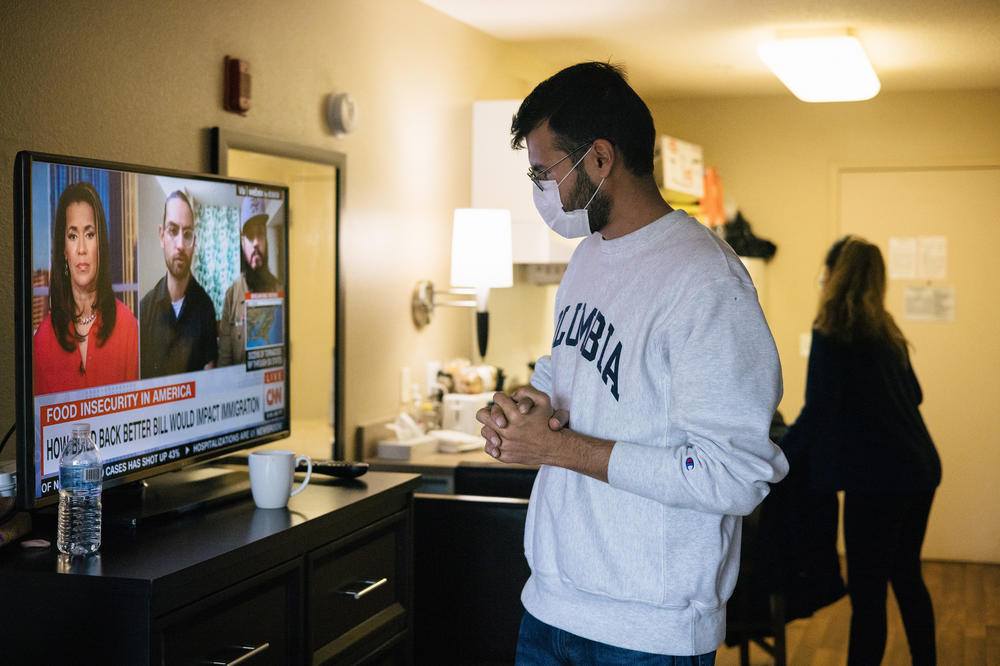 Abdullah Mohib watches the news in his parents' hotel room before moving them into their own apartment.