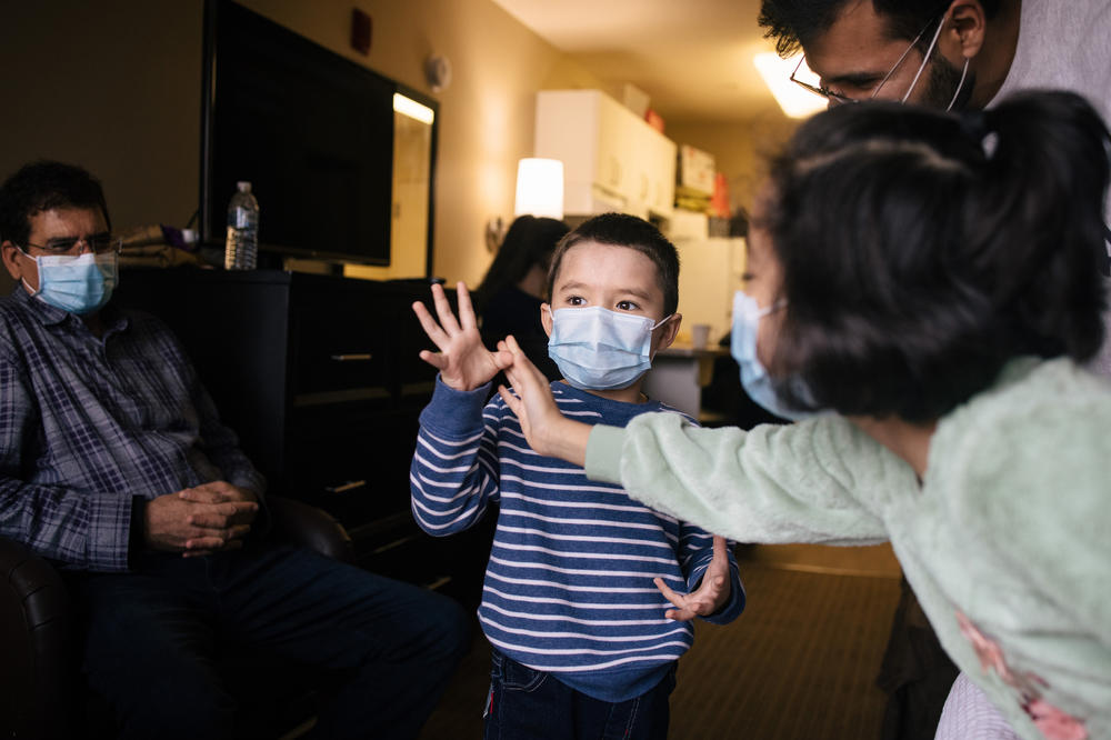 Kamila Noori's grandson Abaseen, 4, shares how old he is with help from his sister Leema, 7, in their grandparents' hotel room in Vienna, Va.