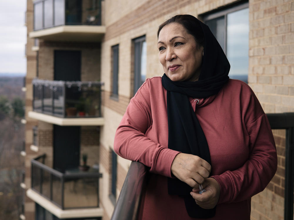After several months of temporarily housing, Kamila Noori, a prominent Afghan judge, stands on the balcony of the apartment where she will live with her husband and two of their daughters.