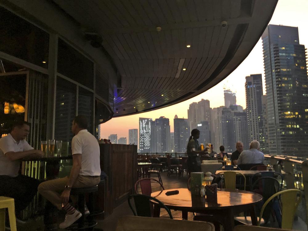 People enjoy drinks at a restaurant overlooking the Marina district in Dubai, United Arab Emirates, in 2019. The country is loosening its liquor laws and other restrictions.