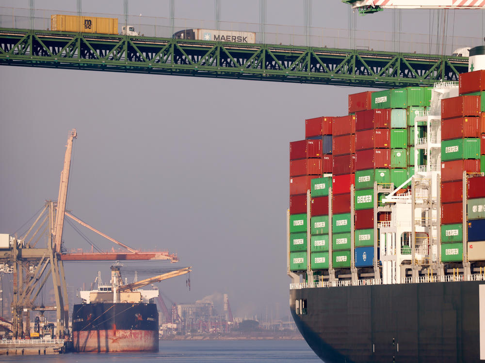 Trucks cross the Vincent Thomas Bridge above a container ship at the Port of Los Angeles on Nov. 30, 2021. Transportation, particularly for moving freight to meet high demand for consumer products, saw the steepest increase in climate-warming emissions in 2021.