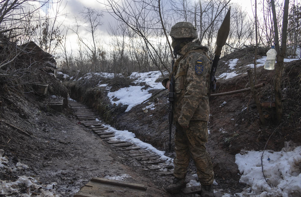 A member of Ukraine's military walks in a trench at the line of separation from pro-Russian rebels, in the Donetsk region, in eastern Ukraine on Friday. President Biden has warned Russia's Vladimir Putin that the U.S. could impose new sanctions against Russia if it takes further military action against Ukraine.