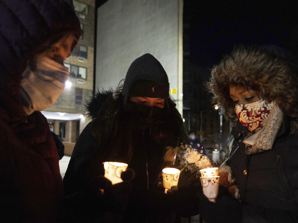 People gather Tuesday evening for a candlelight vigil outside the Bronx apartment building which was the scene of the city's deadliest fire in decades.