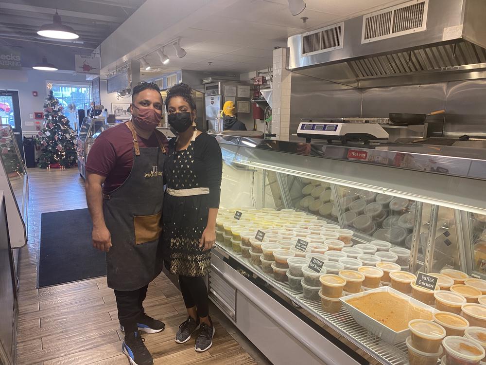 Juby George stands with his wife Shireen Bethala-George at the soft opening of Smell the Curry, a south Indian takeout and catering business at the Flourtown Farmers Market outside Philadelphia, on December 9, 2021.