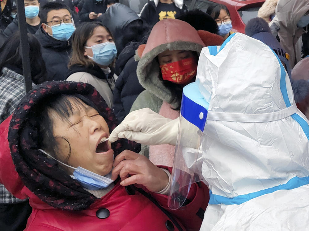 A medical worker takes swab samples on residents in central China's Henan province. The northern city of Tianjin ordered a second round of testing on all 14 million residents Wednesday.