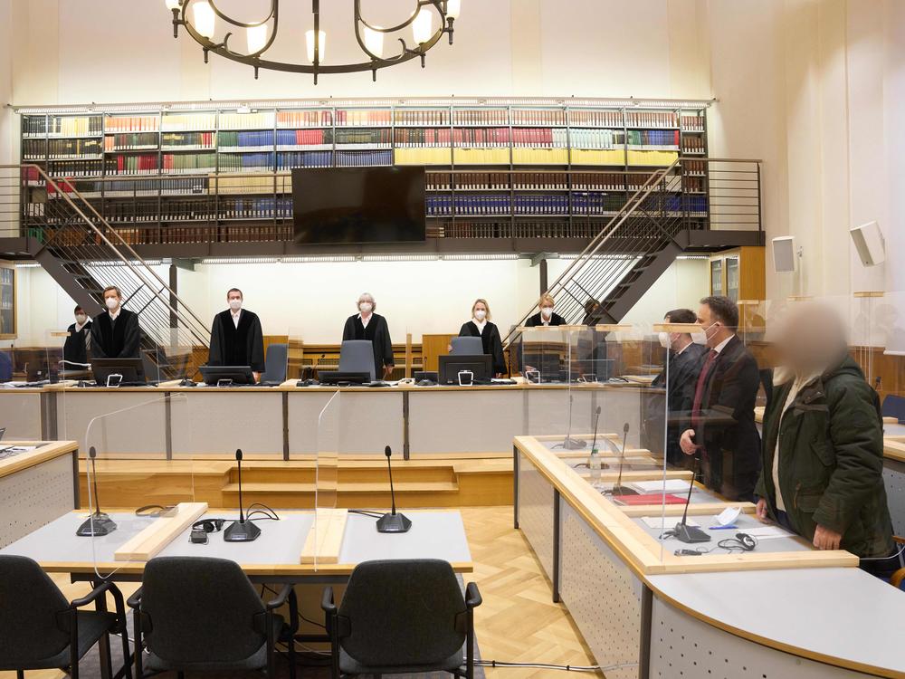 Defendant Anwar Raslan (right) and others involved in his trial stand in the Higher Regional Court in Koblenz, Germany, at the start of a trial session last month. Raslan was put on trial in April 2020 in a landmark case in Germany.