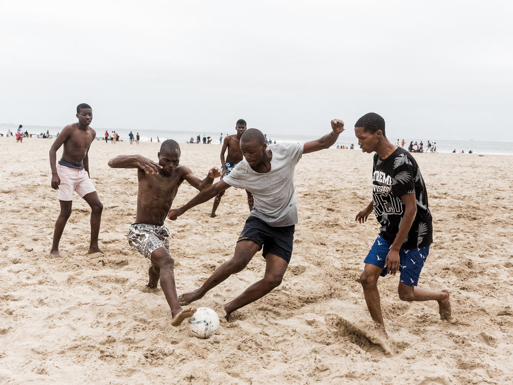 Beachgoers play soccer in Durban, South Africa, during the omicron surge in December 2021.