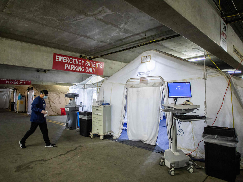 A nurse walks inside a temporary emergency room, built into a parking garage at Providence Cedars-Sinai Tarzana Medical Center in Tarzana, Calif., on Jan. 3, 2021. Since Thanksgiving, cases have risen to the point where 80% of the hospital is filled with patients with COVID-19 and 90% of the ICU is filled with COVID-19.