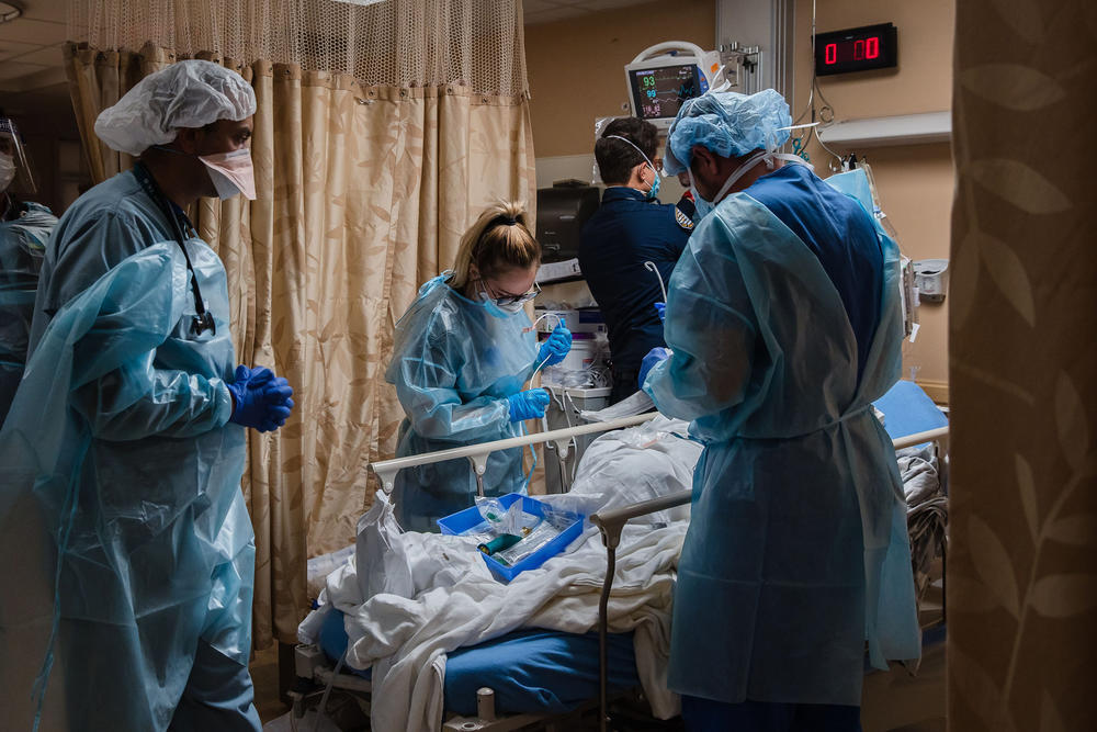 Health care workers tend to a patient with COVID-19 in a COVID holding pod at Providence St. Mary Medical Center in Apple Valley, Calif., on Jan. 11, 2021.