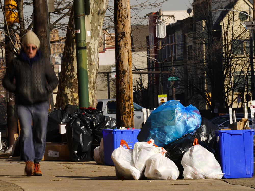 Trash sits out for collection on a Philadelphia street on Thursday. The omicron variant is sickening so many sanitation workers that waste collection in Philadelphia and other cities has been delayed or suspended.
