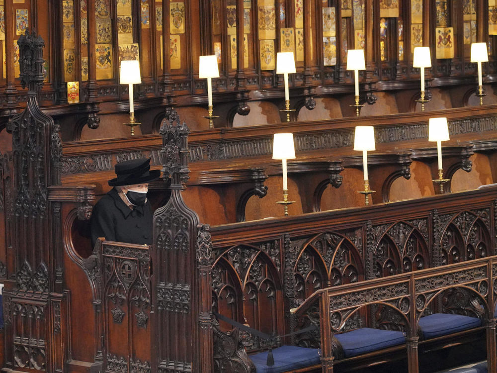 Queen Elizabeth II sits alone in St. George's Chapel on April 17, 2021, during the funeral of Prince Philip.
