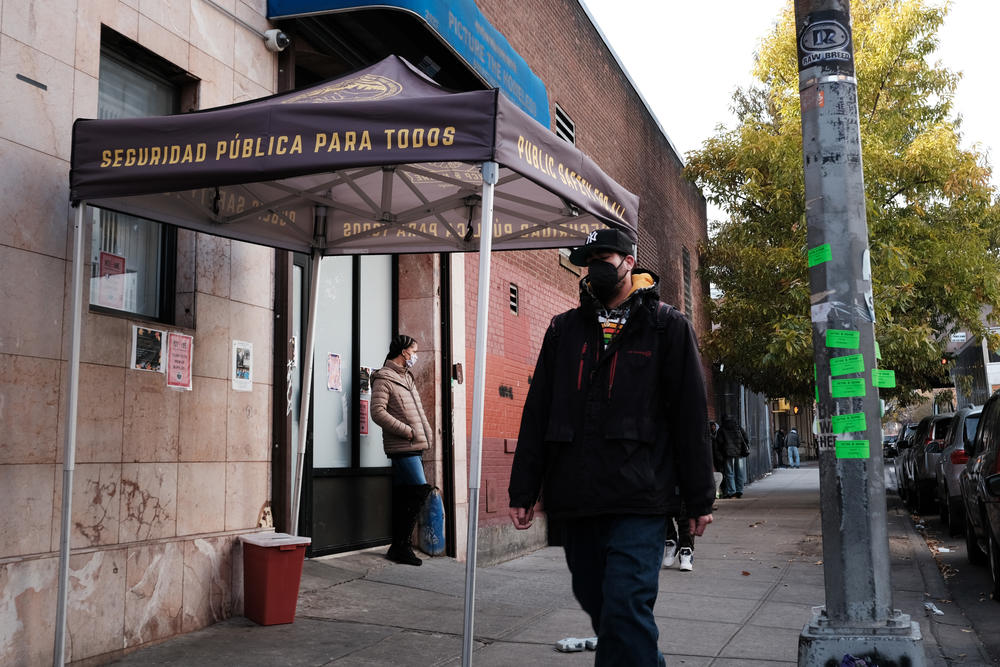 People walk past an East Harlem health clinic that offers free needles and other services to drug users on in New York.