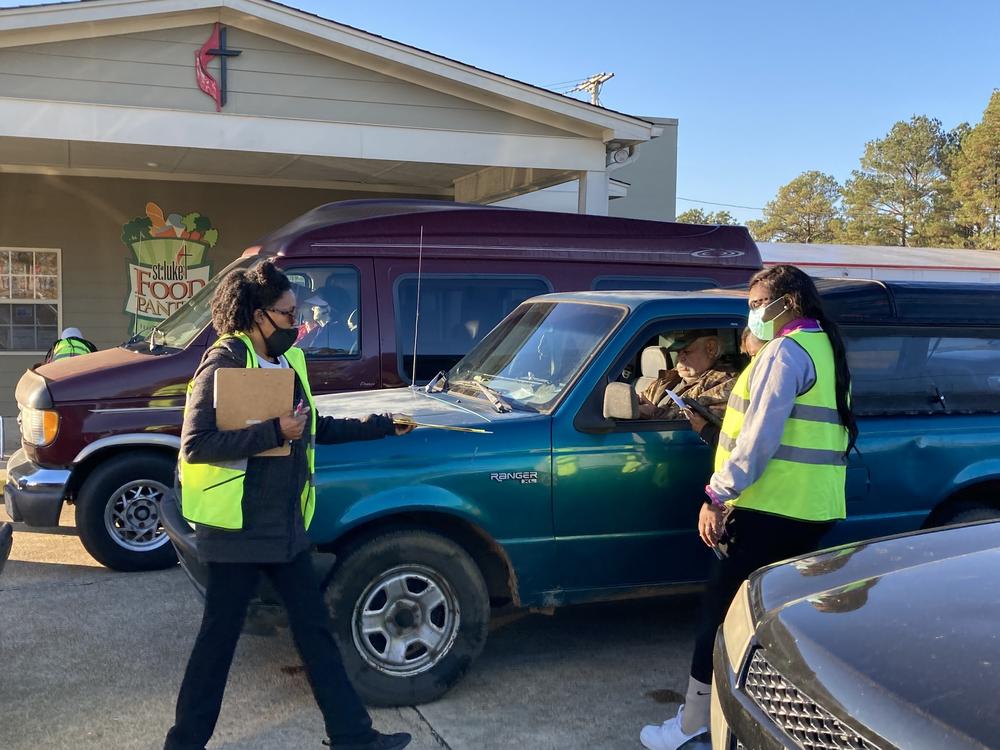 Cars line up to receive food and supplies at the Saint Luke's Food Pantry in Tupelo, Miss., on Dec. 2, 2021. Despite trillions in government aid, many Americans still require help to make ends meet.