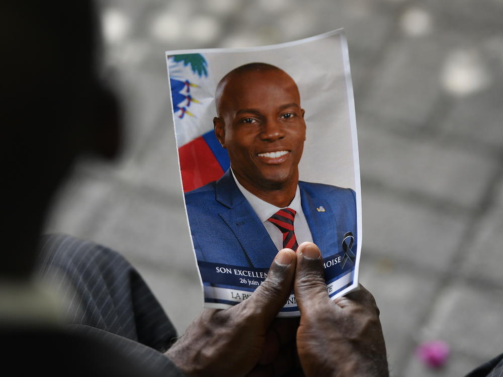 A person holds a photo of late Haitian President Jovenel Moïse during his memorial ceremony in Port-au-Prince, Haiti, on July 20, 2021.