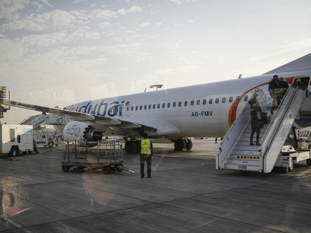 Passengers are taken by bus the plane that will take Novak Djokovic to Belgrade, Serbia, in Dubai, United Arab Emirates, Monday, Jan. 17, 2022.