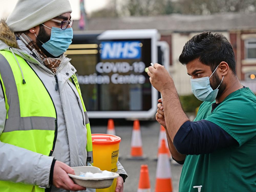 A health service worker draws up a dose of COVID-19 vaccine at a drive-through vaccination center in northwest England on Monday. Dr. Hans Kluge, the WHO regional director for Europe, says increased vaccinations and boosters are a necessary element to stabilize the pandemic across the continent.
