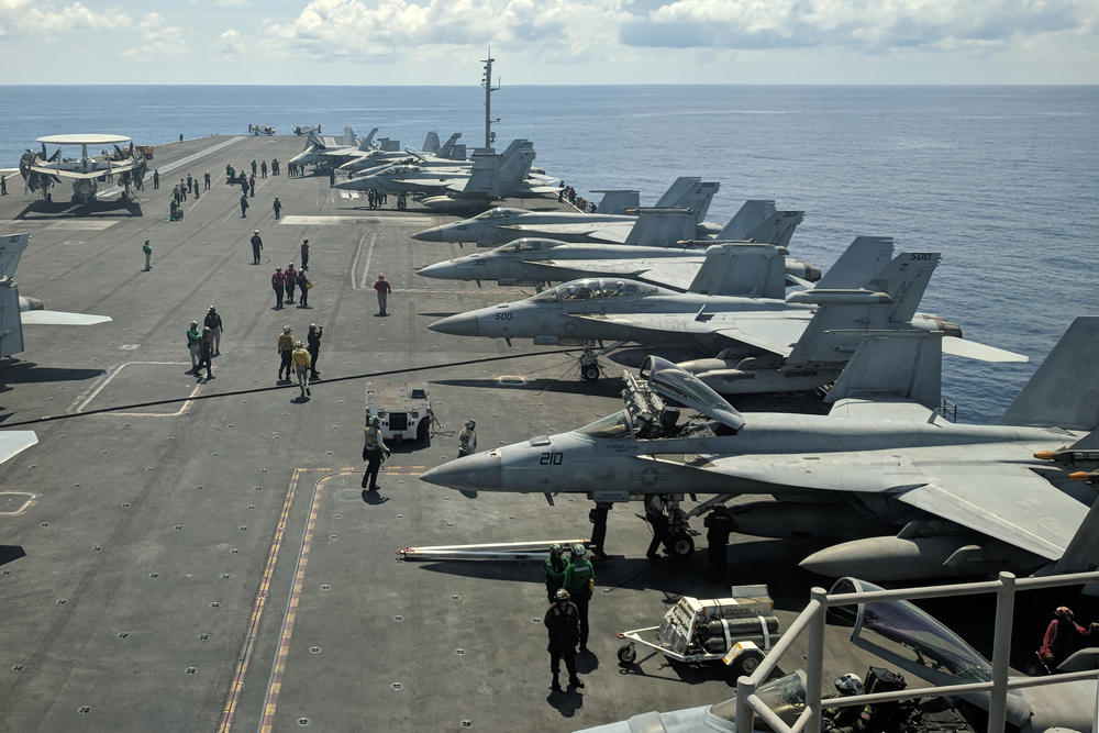 U.S. Navy F/A-18 Super Hornets multirole fighters and an EA-18G Growler electronic warfare aircraft (second right) on board the USS Ronald Reagan (CVN-76) aircraft carrier as it travels in South China Sea on its way to Singapore, on Oct. 16, 2019.