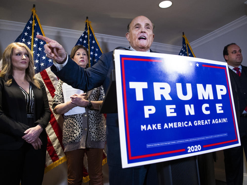 Rudy Giuliani, attorney for then-President Donald Trump, conducts a news conference at the Republican National Committee on lawsuits regarding the outcome of the 2020 presidential election on Nov. 19, 2020. Trump attorneys Jenna Ellis, far left, and Sydney Powell, second from left, and Boris Boris Epshteyn, right, also appear.