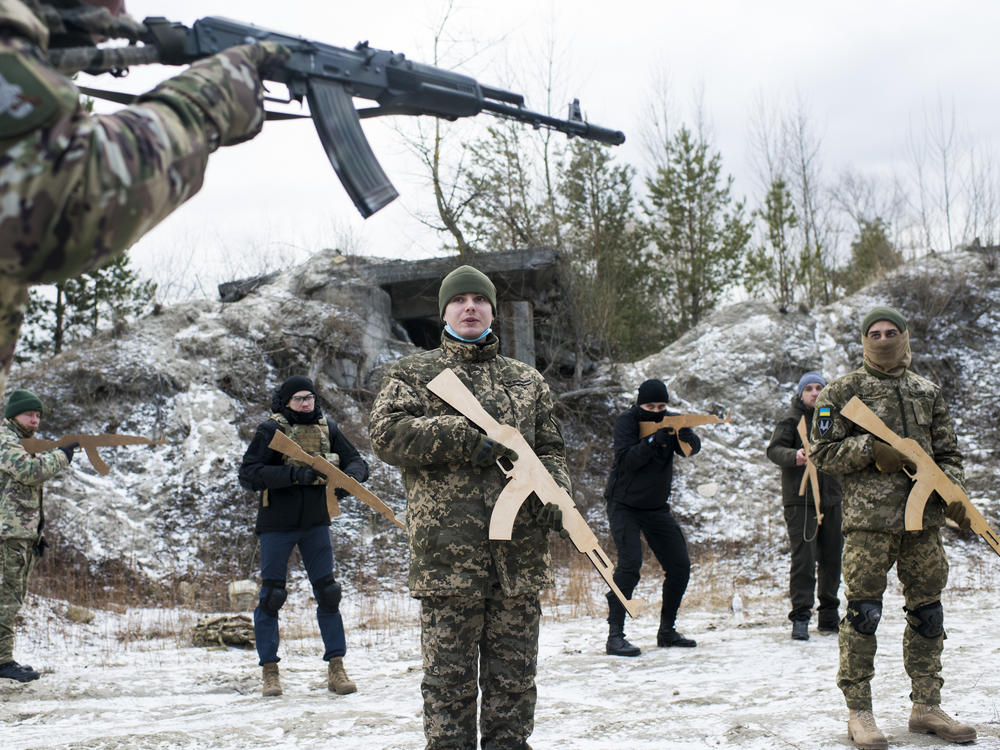 Members of Ukraine's Territorial Defense Forces take part in a Saturday morning training outside Kyiv. New members who have not yet trained with the unit must begin with the basics, and wooden mock weapons, regardless of their experience level.