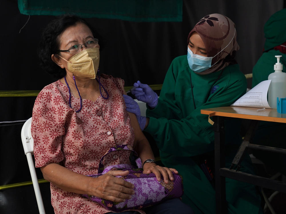 A resident receives a dose of the Pfizer COVID-19 vaccine at a health center in Jakarta, Indonesia, on Jan. 13. This week, Indonesia started a program to give booster shots to the elderly and people at risk of severe disease.