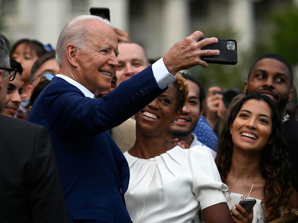 President Biden poses for a selfie with guests after delivering a speech during Independence Day celebrations on the South Lawn of the White House.
