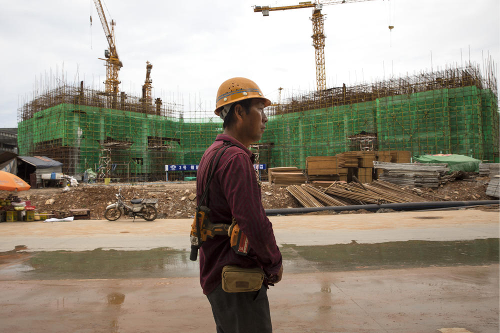 A Chinese worker returns from lunch at a construction site near Otres Beach, in Sihanoukville, Cambodia, Aug. 3, 2018. Money from China accounts for a large share of foreign investment in the Southeast Asian country, creating new roads, airports, skyscrapers, dams, hotels and casinos.