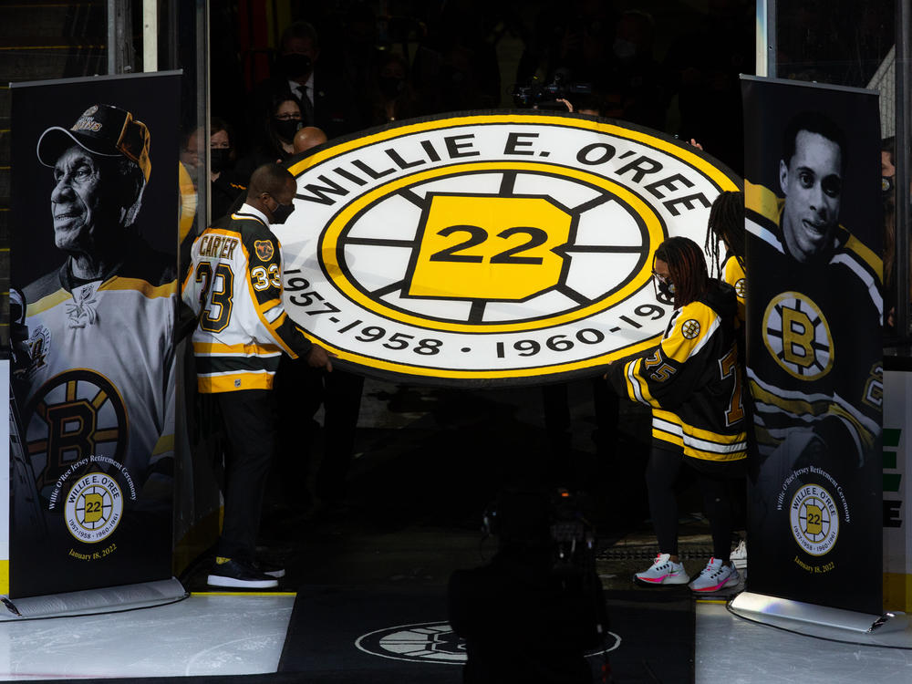 Anson Carter helps carry the banner for former Boston Bruins player Willie O'Ree, as the team retired his No. 22 jersey at the TD Garden Tuesday night.