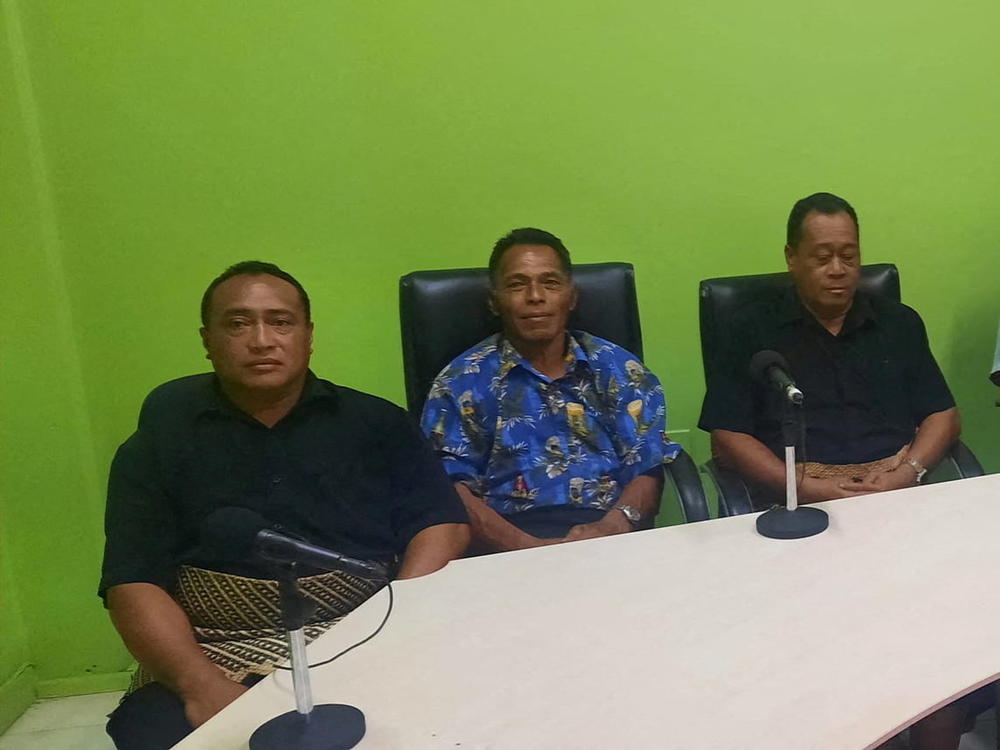Lisala Folau (wearing blue printed shirt) says he swam for more than 24 hours after getting swept to sea by Saturday's tsunami, sits with other people of Atata island in Nuku'alofa, Tonga, on Wednesday in this picture obtained from social media.