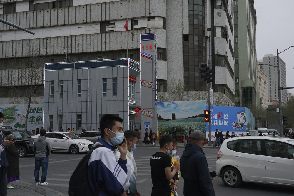 Pedestrians walk past a police station in Urumqi in April 2021. At least 1,300 state boarding schools are set up across Xinjiang.