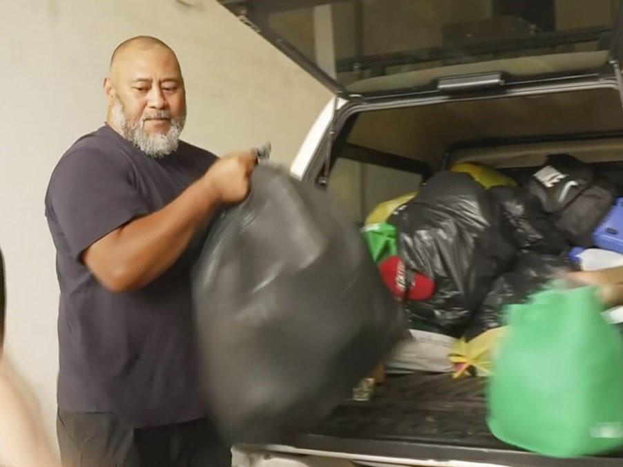 In this image taken from video, Deputy President of the Tonga Australia Chamber of Commerce Koniseti Liutai unpacks relief donations for Tonga from a vehicle on Wednesday, in Sydney, Australia.