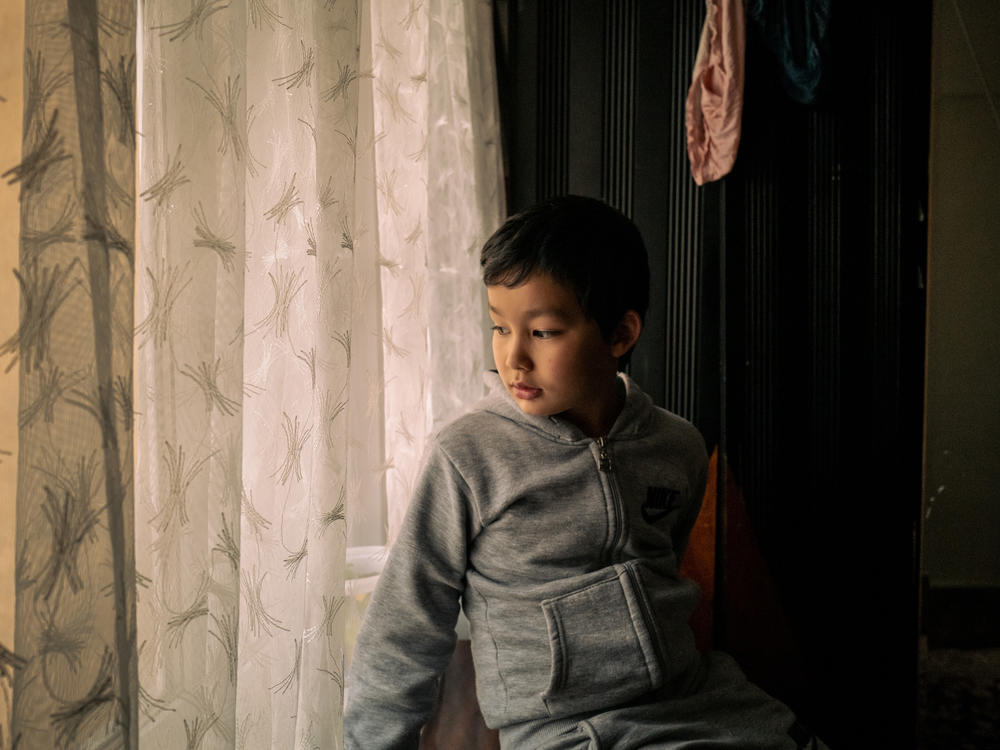 Lütfullah Kuçar, 8, waits at home for his sister, Aysu Kuçar, to return from school, in Istanbul. The two Uyghur children were forcibly separated from their family and spent nearly 20 months in state boarding schools in Xinjiang, China.