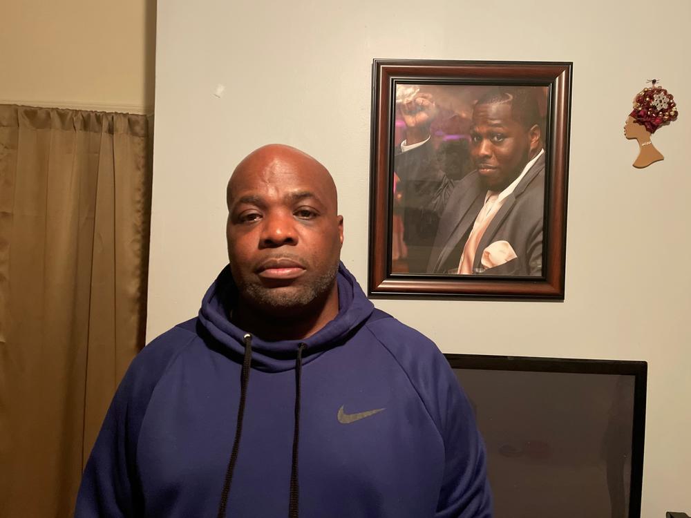 Shawn Williams stands next to a picture of his son, Antonio. He was shot at 15 times and killed by plainclothes officers in the Bronx in 2019