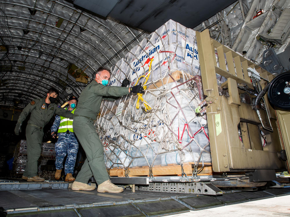 Members of the Australian Defence Force unload humanitarian supplies on Jan. 20 at Tonga's Fuaʻamotu International Airport. Then Tongans distribute the aid.