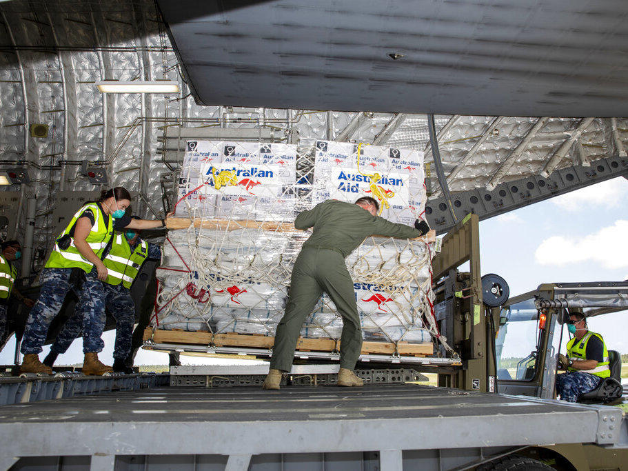In this photo provided by the Australian Defence Force, personnel unload emergency aid supplies at Tonga's Fuaʻamotu International Airport, near Nukuʻalofa, Thursday, Jan. 20, 2022, after a volcano eruption.