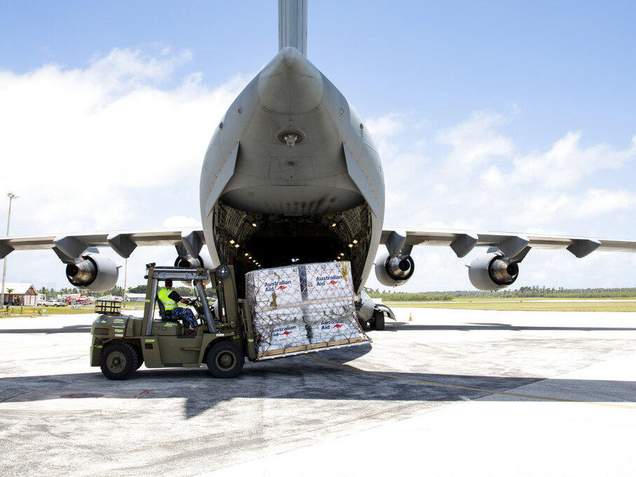 In this photo provided by the Australian Defence Force, personnel unload emergency aid supplies at Tonga's Fuaʻamotu International Airport, near Nukuʻalofa, Thursday, Jan. 20, 2022, after a volcano eruption.