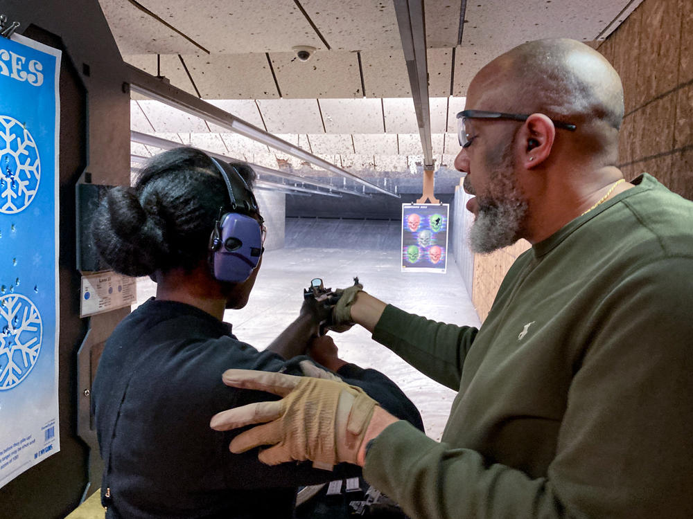 Sharis Lewis of Florissant, Missouri, tries a 12-gauge shotgun with the help of her husband, Russell, at the SharpShooter, an indoor range near south St. Louis.