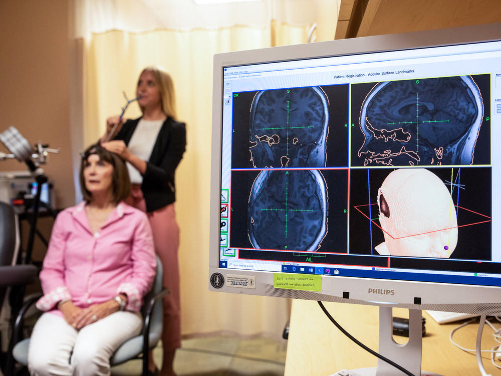 Eleanor Cole, Ph.D., demonstrates the treatment on trial participant Deirdre Lehman in May 2019 at the Stanford Brain Stimulation Lab.