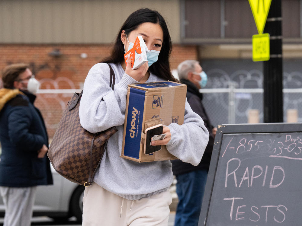 A woman picks up COVID-19 rapid antigen test kits at the Watha T. Daniel-Shaw Neighborhood Library in Washington, D.C., on Wednesday, December 29, 2021.