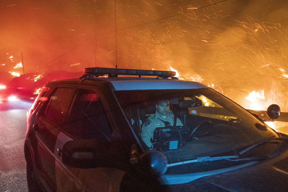 A California Highway Patrol officer drives south on Highway 1 as the Colorado Fire burns near Big Sur, Calif., on Friday.