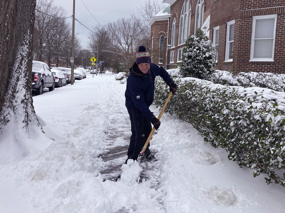 Richard Fuller, 45, shovels a sidewalk in Norfolk, Va., on Saturday. A winter storm left as much of six inches of snow in parts of coastal Virginia and North Carolina as well as ice further south in parts of North Carolina and South Carolina.
