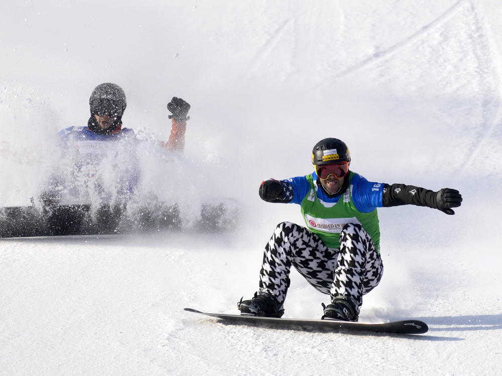 Glenn de Blois of the Netherlands (left) and Nick Baumgartner of the United States cross the finish line during a semifinal of men's snowboard cross at the FIS Snowboard Cross World Cup last November. Snowboard cross is expanding to be mixed gender at the Beijing Winter Olympics.