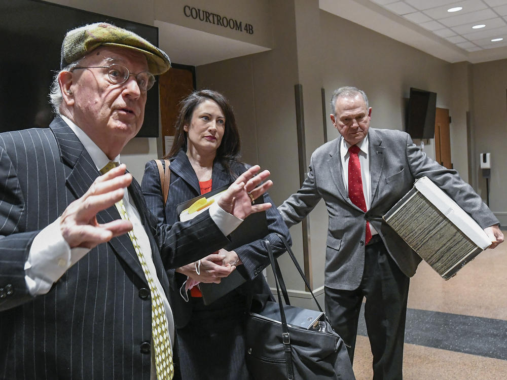Former Alabama Chief Justice Roy Moore, right, and his attorney Julian McPhillips, left, leave the courtroom in Montgomery, Ala., on Monday following jury selection. Moore and Leigh Corfman, who accused him of sexual assault, are suing each other for defamation.