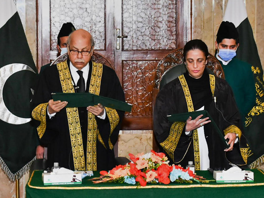 In this photo provided by Pakistan's Press Information Department, Pakistan's Chief Justice Gulzar Ahmad, left, administrates the oath of office to Ayesha Malik in Islamabad, Pakistan on Monday. Malik is the first female judge to serve on Pakistan's Supreme Court.