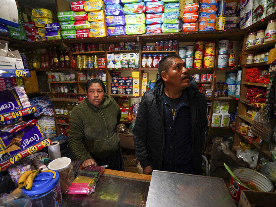 Jose Gonzalez and his wife Maria, wait for customers in their corner shop that he remodeled, stocked and extended with money he earned over a decade working in the United States, in the Purepecha Indigenous community of Comachuen, Michoacan state, Mexico, Wednesday, Jan. 19, 2022. (AP Photo/Fernando Llano)