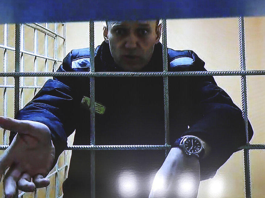 Russian opposition leader Alexei Navalny gestures as he speaks via a video link from a prison during a court session in Petushki, Vladimir region, about 120 kilometers (75 miles) east of Moscow, Russia, Tuesday, Dec. 28, 2021.