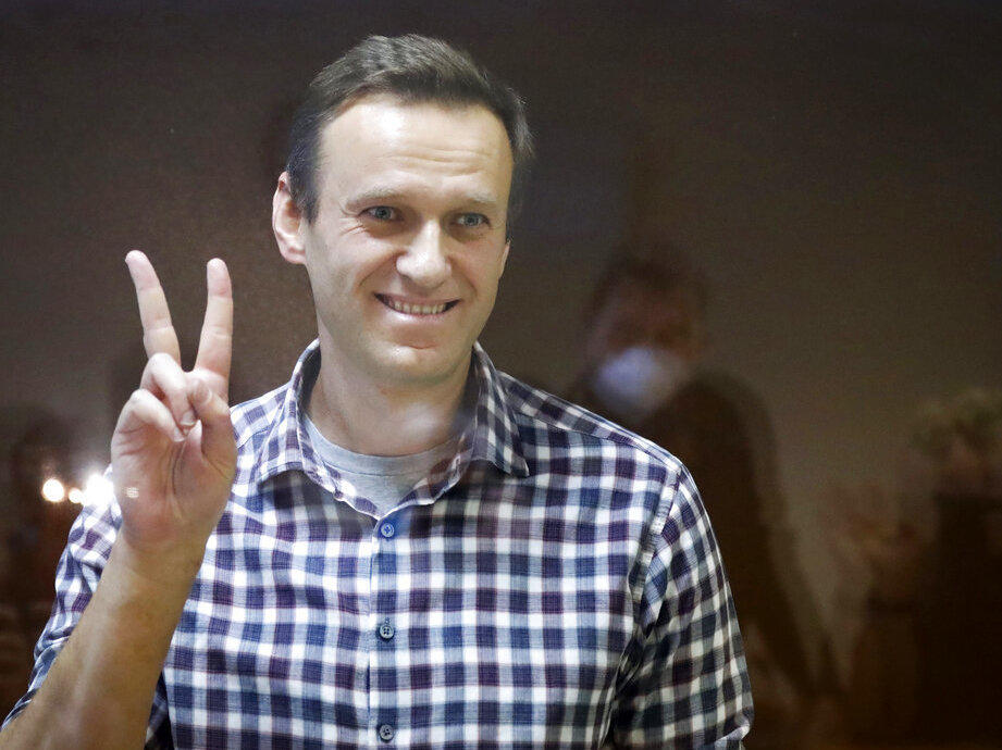 Russian opposition leader Alexei Navalny gestures as he stands in a cage in the Babuskinsky District Court in Moscow, Russia, Saturday, Feb. 20, 2021.