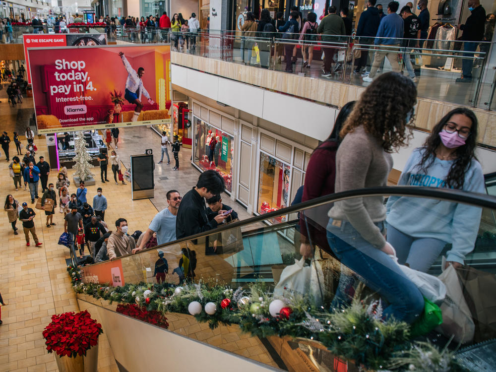 People shop in The Galleria mall in Houston during Black Friday on Nov. 26, 2021. The economy grew strongly last year but at an uneven pace because of the pandemic.