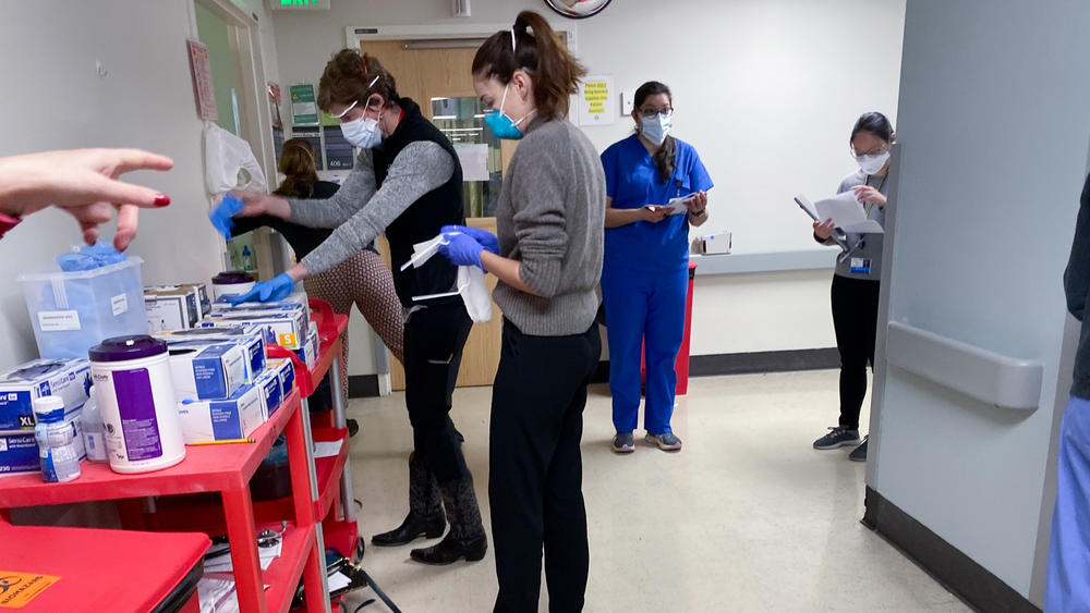 The flood of COVID cases at Harborview Medical Center adds to the workload of nursing and medical staff, who must pick up duties like cleaning room and delivering meals to lessen the number of people exposed to the virus.
